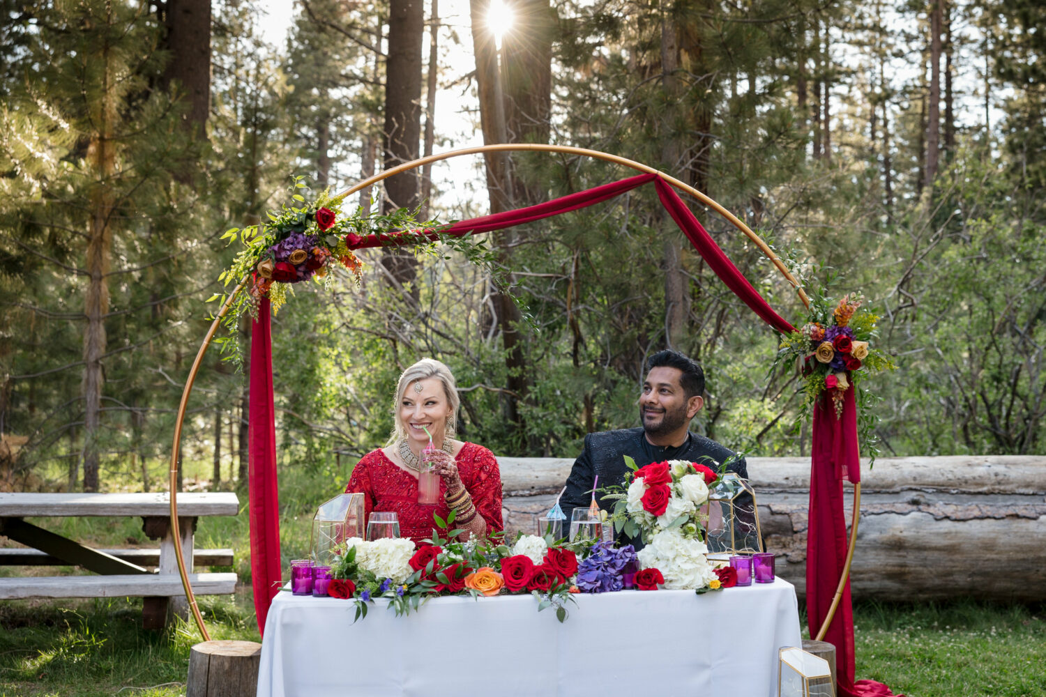 The bride and groom sip non-alcoholic wedding drinks at the sweetheart table on the Valhalla Tahoe lawn. 