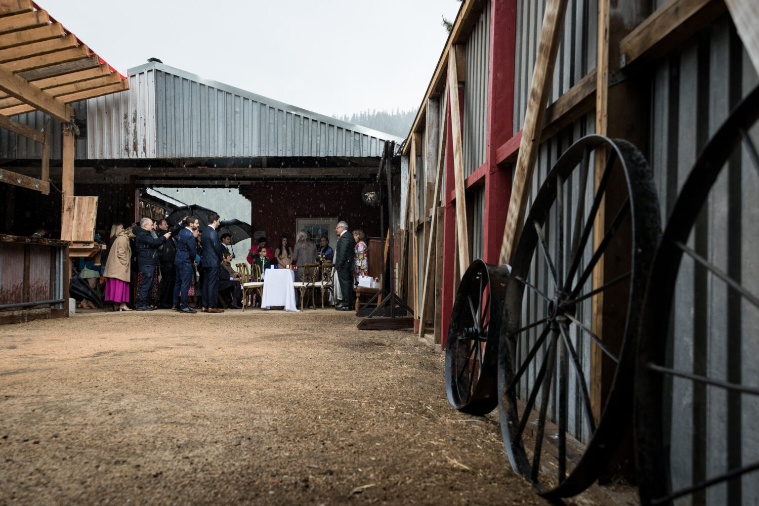 The wedding party takes shelter from the rain at an Olympic Valley Stables wedding.