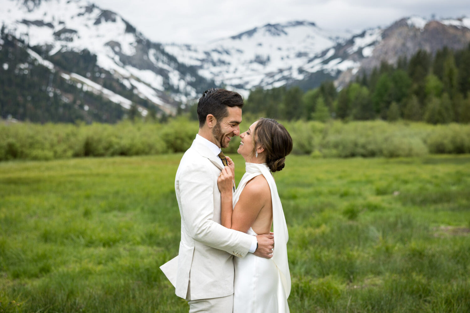 A groom and bride embrace for their first look in the meadow in Olympic Valley.