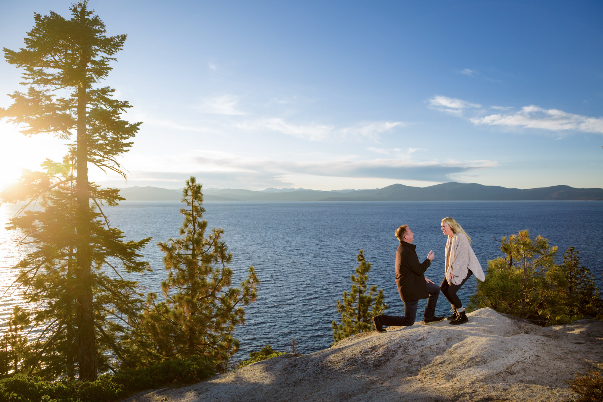A man gets on one knee for a surprise wedding proposal high above Lake Tahoe.