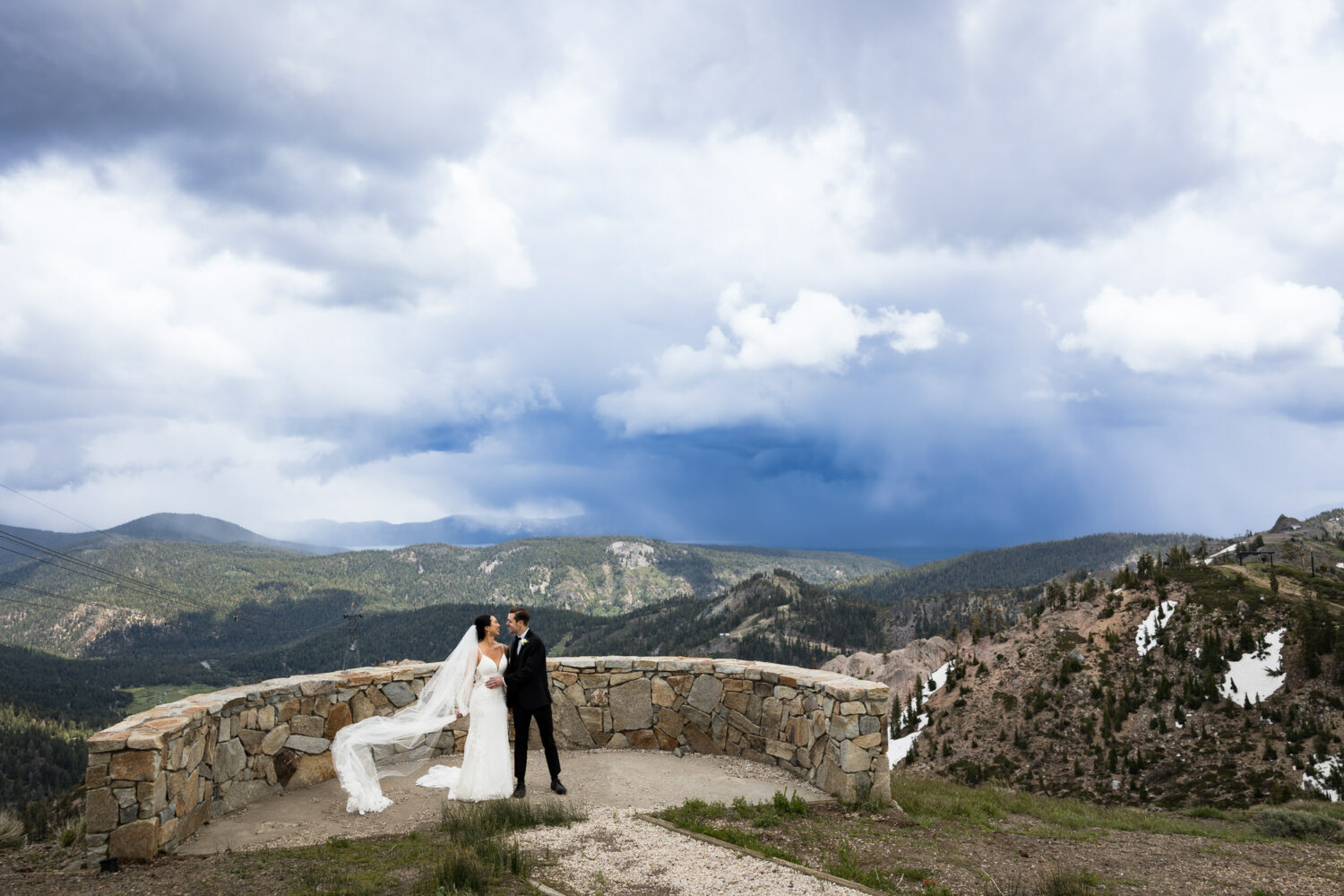 Storm clouds cover Lake Tahoe are a backdrop for a bride and groom's first look at High Camp.