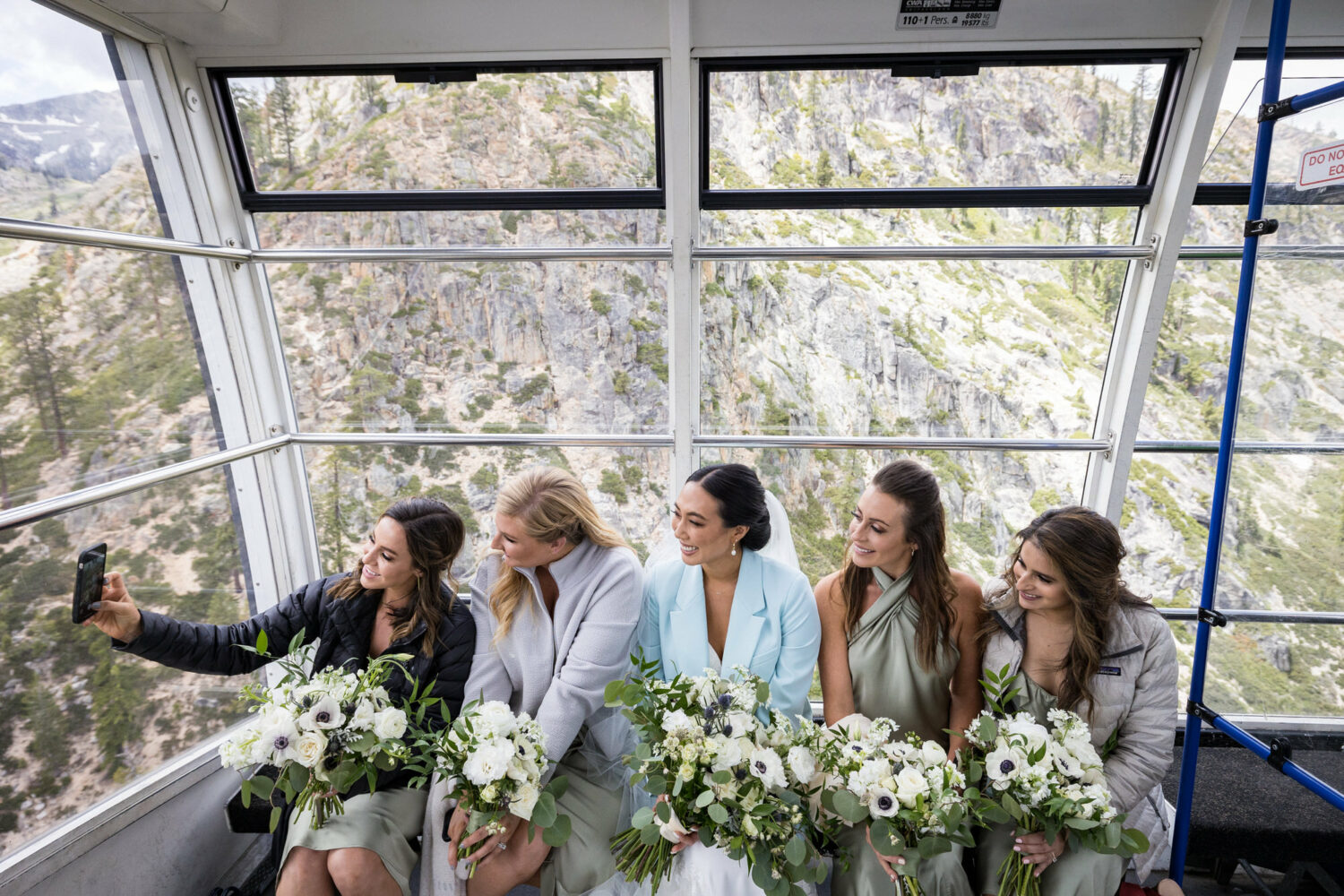 Bridesmaids taking a selfie as the wedding party rides the Palisades Aerial Tram.