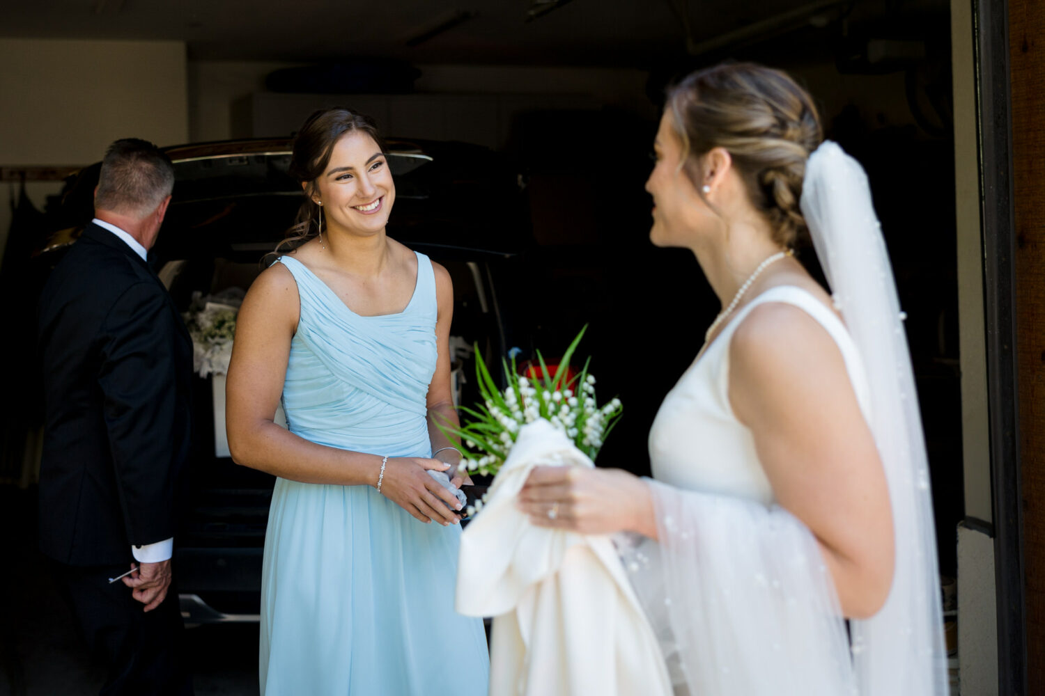 The sister of the bride is ready for the big day, wearing a sleeveless baby blue bridesmaid dress.