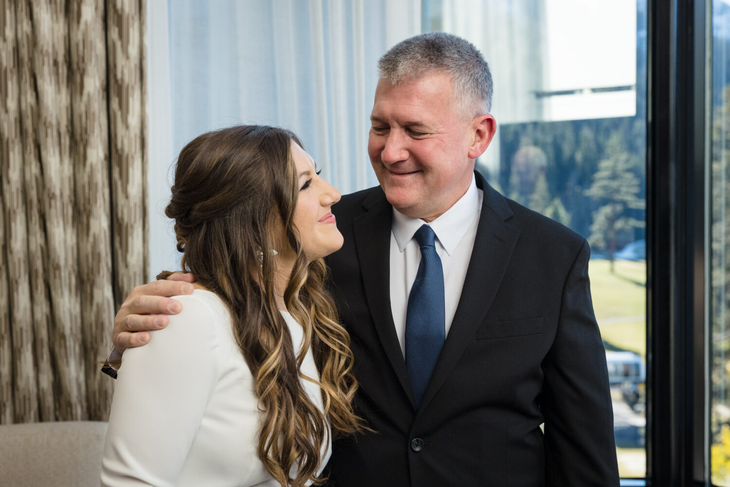 The bride and her dad enjoy an emotional moment during their father and daughter wedding day first look.