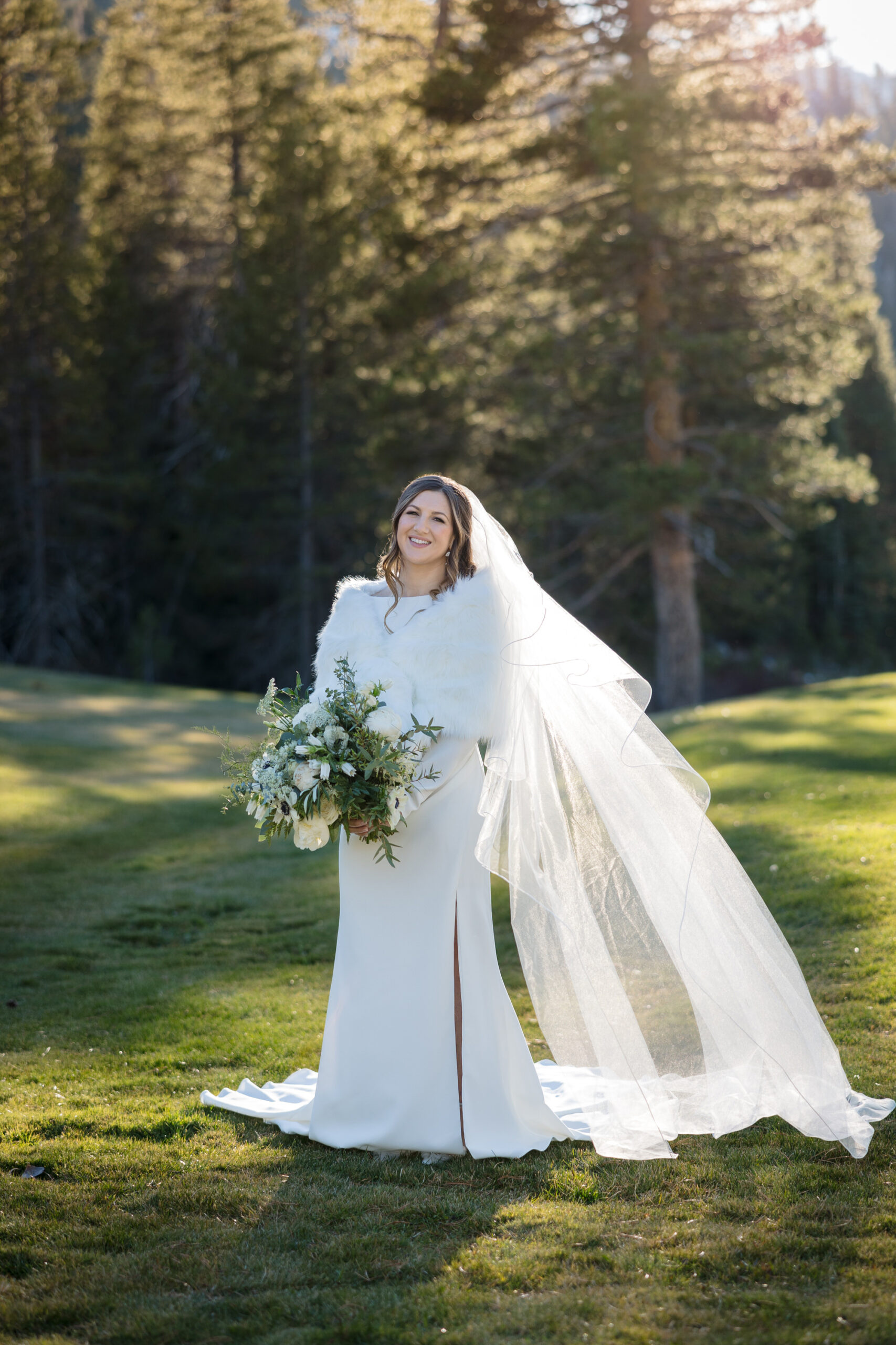 Sunset portrait of a bride wearing a white fur wrap for a winter wedding.