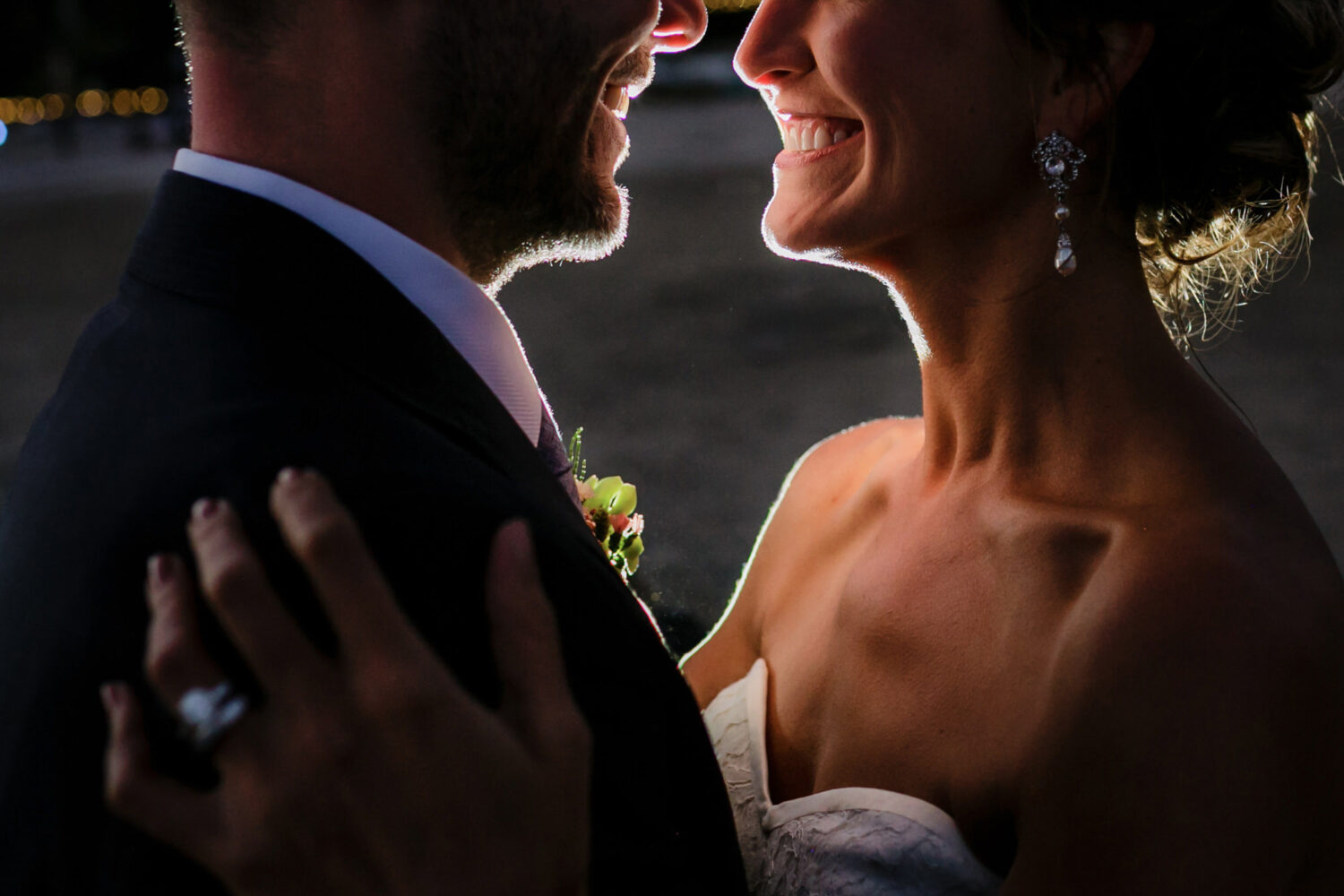 An up-close portrait of a bride and groom on the beach at twilight.