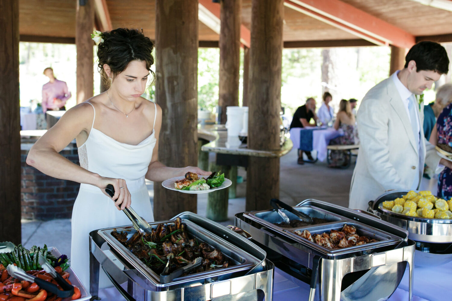A bride expresses a moment of overwhelm as she helps herself to a Lake Tahoe catering company creation.