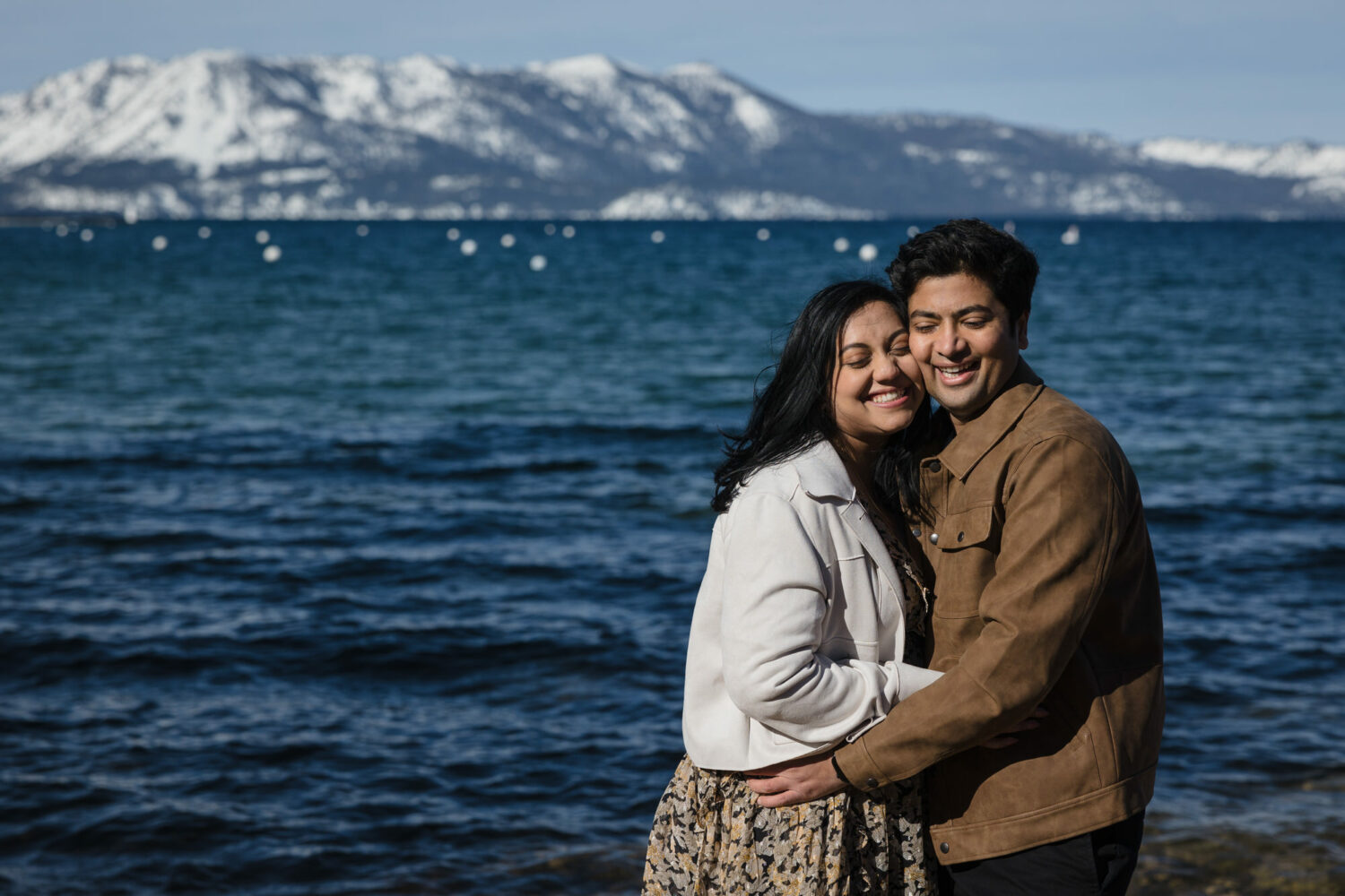 Surprise proposal in front of Lake Tahoe with the mountain range visible in the background.