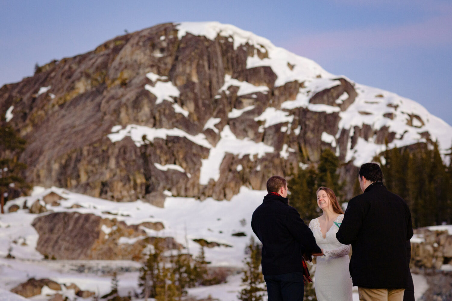A couple that decided to have an intimate elopement on Donner Summit exchanges vows with mountains in the background.