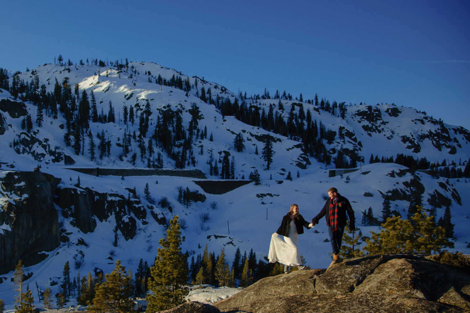 A couple explores the snowy mountain landscape at a winter elopement in Lake Tahoe.